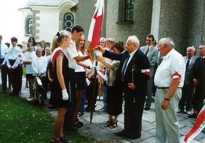 Uroczyste przekazanie sztandaru: dorośli wręczają sztandar uczniom.