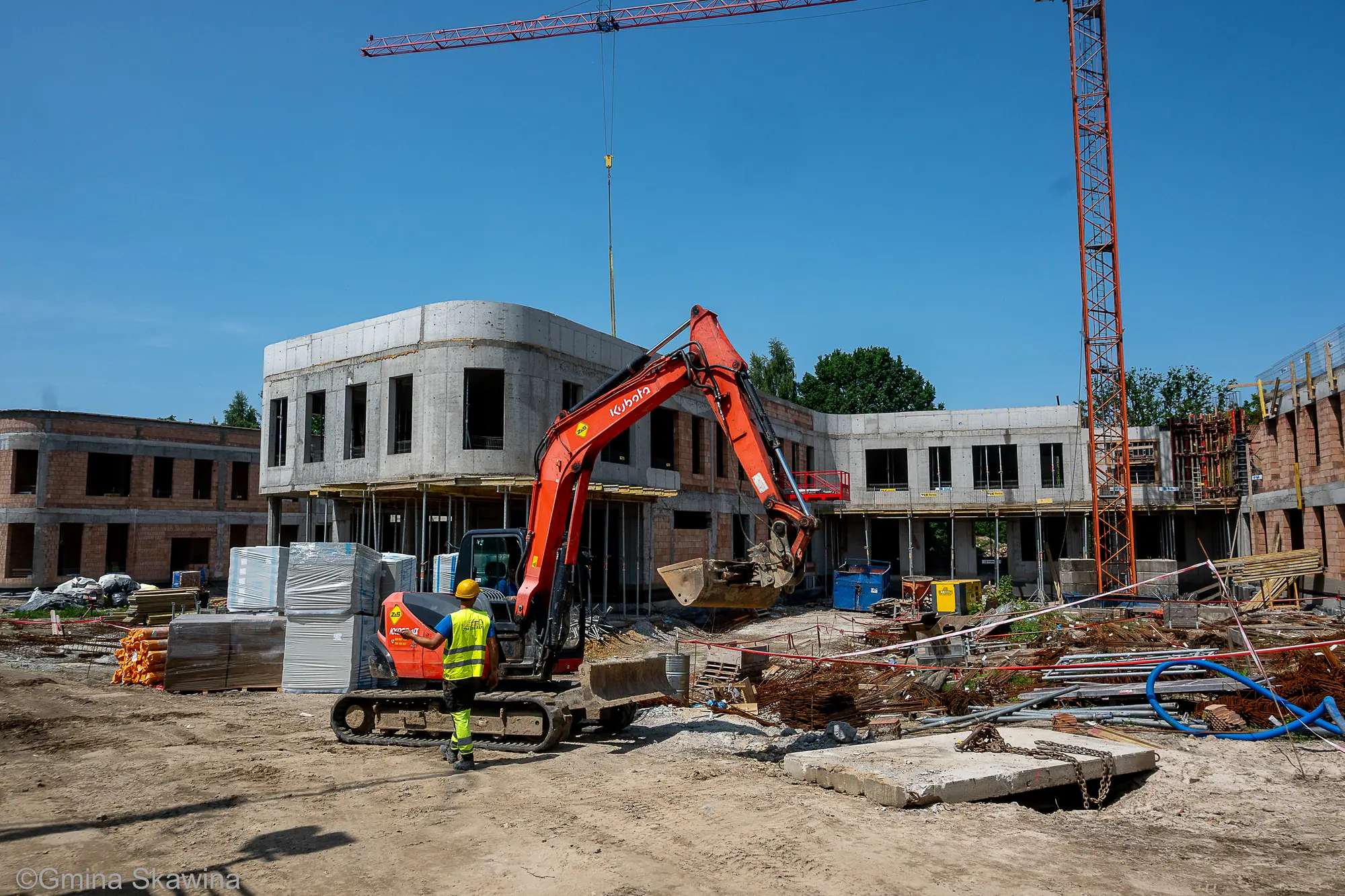 Wnętrze budynku w stanie surowym: ceglane ściany, betonowy strop, otwory okienne.